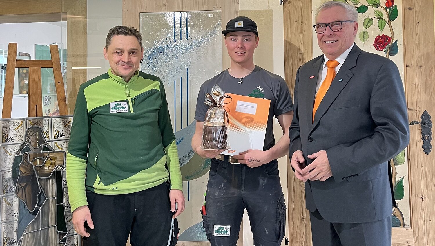 Firmenbesuch mit Geschenkübergabe bei Glas Eberle v. l. : Tobias Eberle (GF), Luca Eberle (Bundessieger), HWK-Präsident Hans-Peter Rauch