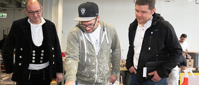 Franz Motz, Obermeister der Zimmerer-Innung Donau-Ries (links) und Johann Marton, stv. OM der Bau-Innung Kempten (rechts) schauen beim Rundgang durch die Werkstätten einem Meisterschüler im Maler-und Lackiererhandwerk über die Schulter. Franz Motz, Obermeister der Zimmerer-Innung Donau-Ries (links) und Johann Marton, stv. OM der Bau-Innung Kempten (rechts) schauen beim Rundgang durch die Werkstätten einem Meisterschüler im Maler-und Lackiererhandwerk über die Schulter.