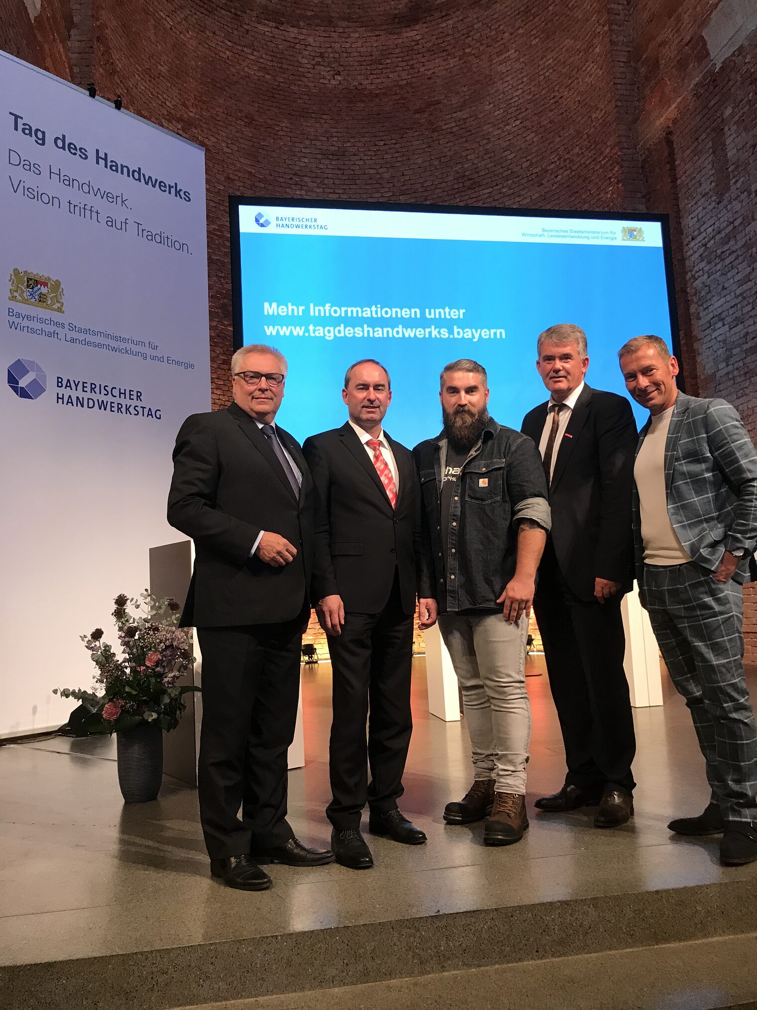 v.l. Hans-Peter Rauch, HWK-Praesident, Hubert Aiwanger, Bayerischer Wirtschaftsminister, Influencer Karl Preiser, Bauprofi Preiser, Ulrich Wagner, HWK-Hauptgeschaeftsfuehrer, und Moderator Markus Othmer beim Tag des Handwerks 2019 in Bayern in der Allerheiligen Hofkirche in Muenchen